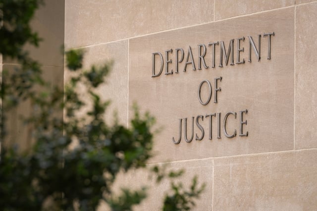 A sign marks the location of the U.S. Department of Justice headquarters building on April 30, 2025, in Washington, D.C.