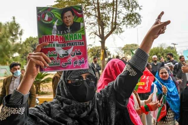A supporter of Pakistan's former prime minister Imran Khan hold his portrait during a protest