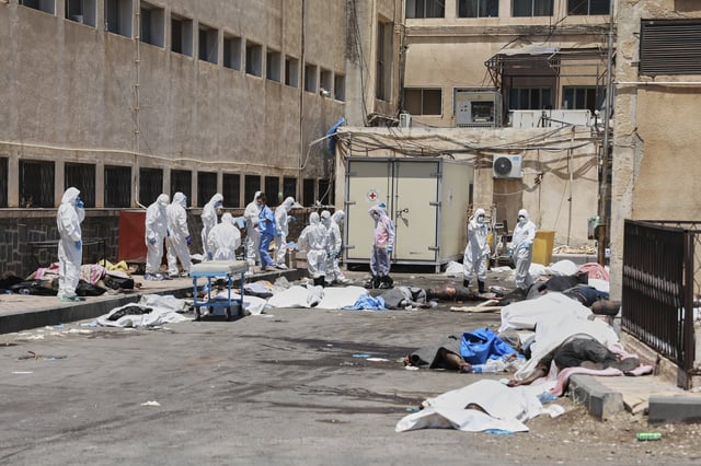 EDS NOTE: GRAPHIC CONTENT - Morgue workers place the bodies of unidentified people killed during clashes between Bedouin clans and Druze militias, into plastic bags outside the National Hospital in Sweida, Syria, Monday, July 21, 2025. (AP Photo/Fahd Kiwan)
