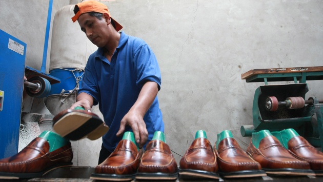 Un zapatero trabaja en una fábrica de zapatos.