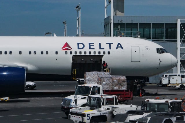 A staff uploads packages on Delta Air Lines plane at John F. Kennedy International Airport in Queens, New York City, U.S., April 23, 2025. REUTERS/Jeenah Moon/File Photo