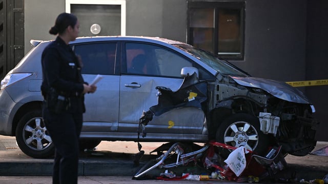 Officers stand at the scene of a crashed vehicle which drove into a crowd in Hollywood in the early hours of July 19, 2025, injuring 28 people, according to the Los Angeles Fire Department. More than 100 firefighters responded to the scene in East Hollywood assisting three patients in critical condition, six in serious condition and 19 listed as fair, the Fire Department said. (Photo by Robyn BECK / AFP) (Photo by ROBYN BECK/AFP via Getty Images)