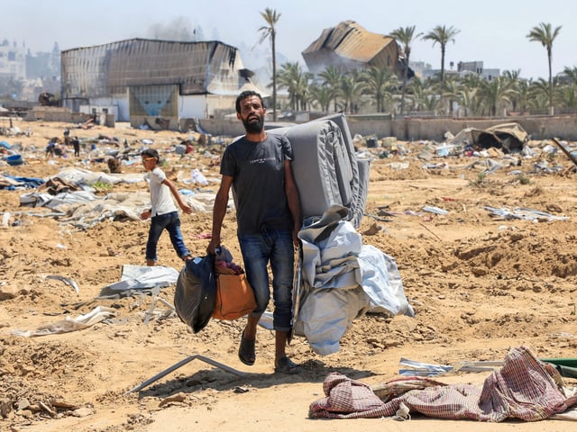 A displaced Palestinian walks in the aftermath of an Israeli military operation in Deir Al-Balah, in the central Gaza Strip, July 22, 2025. REUTERS/Hatem Khaled     TPX IMAGES OF THE DAY