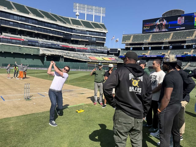 Australian cricket legend Adam Gilchrist demonstrates how to swing a cricket bat in front of Oakland Ballers players and staff at the Oakland Coliseum recently. Alameda County officials voted Tuesday to approve the Oakland As&#39; sale of its half of the facility to an investor group.