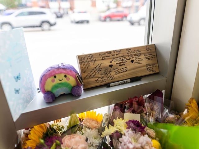 Flowers, cards and other tributes left for 23-year-old Madisson Cobb in the entrance to the Calgary parking garage where she was fatally shot. 