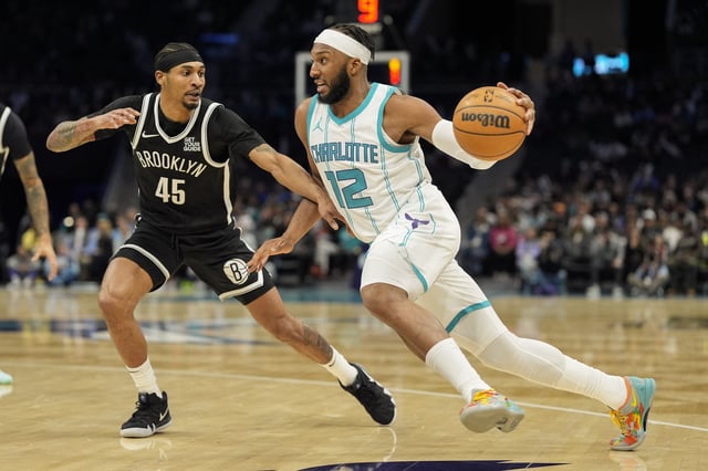 Jan 29, 2025; Charlotte, North Carolina, USA; Charlotte Hornets forward Josh Okogie (12) drives to the basket against Brooklyn Nets guard Keon Johnson (45) during the second half at Spectrum Center. Mandatory Credit: Jim Dedmon-Imagn Images/File Photo