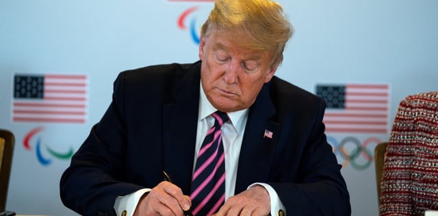 President Donald Trump signs a document pledging the support of the federal government during a briefing with the U.S. Olympic and Paralympic Committee and Los Angeles 2028 organizers, Tuesday, Feb. 18, 2020, in Beverly Hills, Calif. (AP Photo/Evan Vucci)