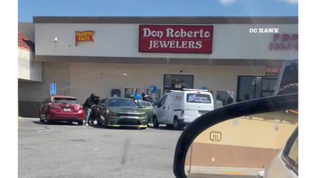 Four masked robbers are seen leaving after stealing an unknown amount of jewelry from Don Roberto Jewelers on West La Palma Avenue in Anaheim. They took off in a Dodge Charger on Tuesday afternoon, July 22, police said. (Photo from a witness provided by OC Hawk)