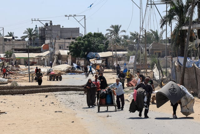Displaced Palestinian walk with their belongings in the aftermath of an Israeli military operation in Deir Al-Balah, in the central Gaza Strip, July 22, 2025. REUTERS/Hatem Khaled