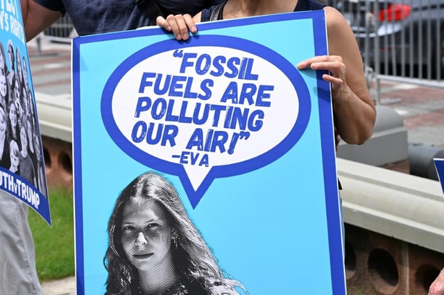 Une banderole avec une citation d'Eva Lighthiser,   à la tête d'un combat judiciaire contre la politique du président américain Donald Trump favorable aux énergies fossiles, lors d'une manifestation devant le Congrès, à Washington, le 16 juillet 2025