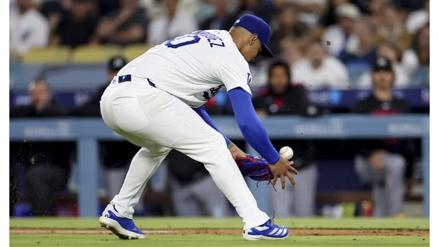 Dodgers relief pitcher Edgardo Henriquez fumbles the ball before his errant throw into right field allowed three runs to score during the seventh inning of a game against the Minnesota Twins on Tuesday night at Dodger Stadium. (AP Photo/Eric Thayer)