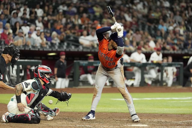 Houston Astros&#39; Brice Matthews, right, avoids a wild pitch as the ball gets past Arizona Diamondbacks catcher Jose Herrera, second from left, as home plate umpire Vic Carapazza, left, looks on during the ninth inning of a baseball game Tuesday, July 22, 2025, in Phoenix. (AP Photo/Ross D. Franklin)