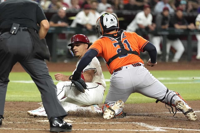 Houston Astros catcher Yainer Diaz, right, tags out Arizona Diamondbacks&#39; Alek Thomas trying to score a run during the seventh inning of a baseball game Tuesday, July 22, 2025, in Phoenix. (AP Photo/Ross D. Franklin)