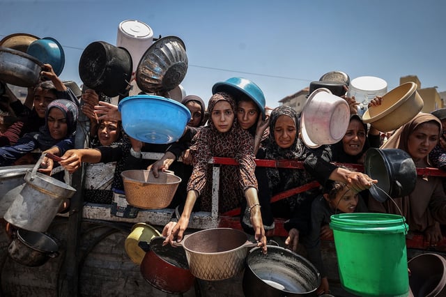 GAZA CITY, GAZA - JULY 22: Crowds form as Palestinians, including children, line up in Gaza City, Gaza to receive food distributed by a charity amid ongoing Israeli blockade and attacks on Gaza on July 22, 2025. (Photo by Ali Jadallah/Anadolu via Getty Images)