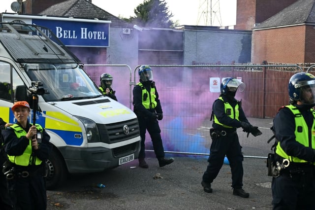 Des fusées éclairantes lancées sur des policiers lors d'une manifestation devant l'hôtel Bell, censé héberger des demandeurs d'asile, à Epping, au nord-est de Londres, le 20 juillet 2025, après que la police a inculpé un demandeur d'asile pour infractions sexuelles