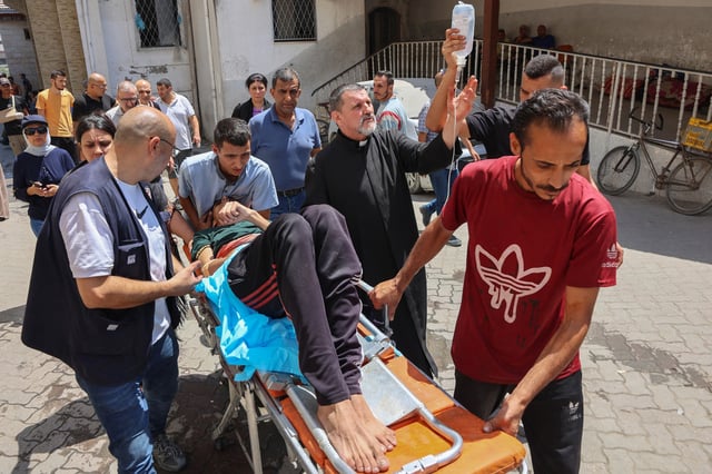 Palestinians who were injured in an Israeli strike on the Holy Family church receive treatment in Gaza City's Arab Ahli, also known as Baptist, hospital on July 17, 2025. 