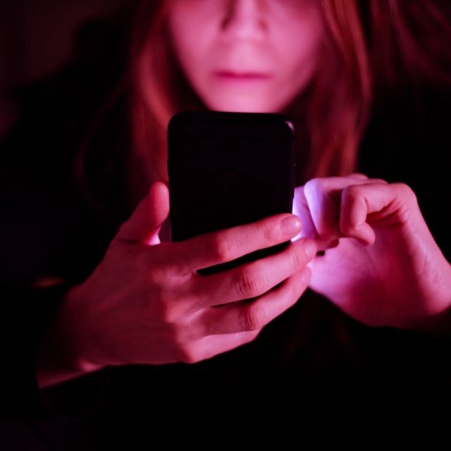 bottom half of a woman's face as she uses a cellphone