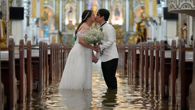 Newlyweds Jade Rick Verdillo right, and Jamaica kiss during their wedding at the flooded Barasoain church in Malolos.