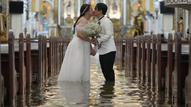 Newlyweds Jade Rick Verdillo and Jamaica Aguilar kiss during their wedding at the flooded Barasoain church in Malolos, Bulacan province, Philippines, on July 22, 2025.