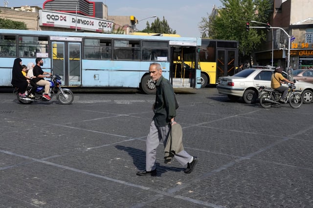 A man crosses an intersection on a hot summer day in downtown Tehran, Iran, Monday, July 21, 2025. (AP Photo/Vahid Salemi)