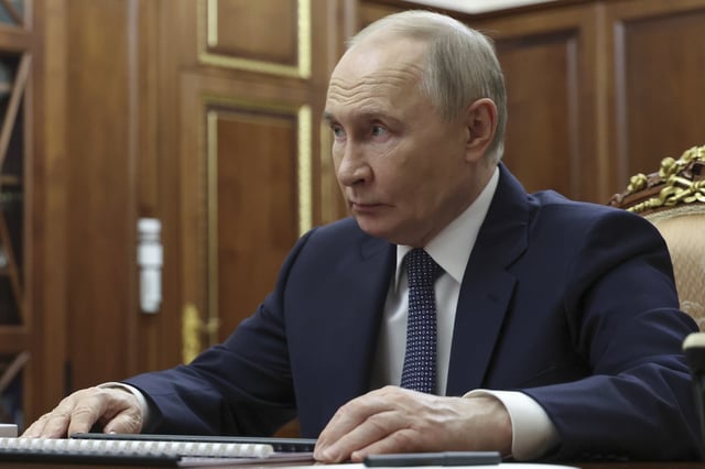 Russian President Vladimir Putin listens to Minister of Justice of the Russian Federation Konstantin Chuychenko during their meeting at the Kremlin in Moscow, Russia, Tuesday, July 22, 2025.