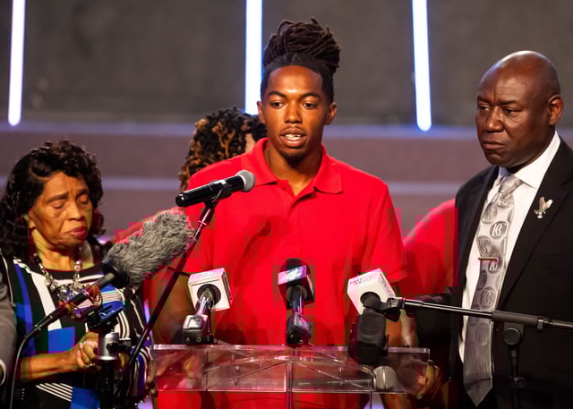 William McNeil Jr., 22-yr-old, center, answers a few questions as his Attorney Ben Crump, right, and his great-grandmother Annette James, left, stand at his side during a press conference.
