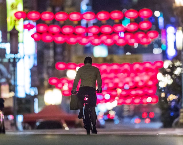 A bicyclist rides their bike down a nearly empty Grant Street in San Francisco’s Chinatown during a COVID-19 surge in December 2020.