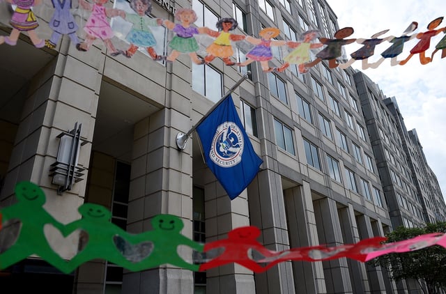 In this July 2020 photo, paper dolls are held by demonstrators protesting outside the Immigration and Customs Enforcement headquarters in Washington, DC.