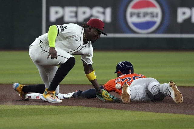 Houston Astros&#39; Taylor Trammell (26) steals second base under the tag by Arizona Diamondbacks shortstop Geraldo Perdomo in the first inning of a baseball game, Wednesday, July 23, 2025, in Phoenix. (AP Photo/Rick Scuteri)