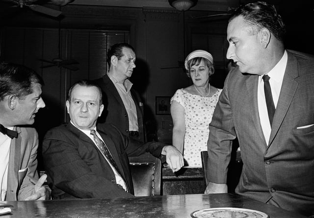 FILE - Jack Ruby, second from left, talks with defense attorney Sam Houston Clinton, Jr., far left, after District Judge Louis Holland denied a defense motion for a hearing to disqualify Judge Joe B. Brown from further proceedings in the case in which Ruby was convicted and sentenced to death for the shooting of presidential assassin Lee Harvey Oswald, in Dallas, July 24, 1965. (AP Photo/Ferd Kaufman, File)