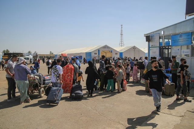 Des réfugiés afghans arrivent avec leurs biens après avoir traversé la frontière avec l'Iran, à Islam Qala, dans la province d'Herat, le 24 juillet 2025 en Afghanistan