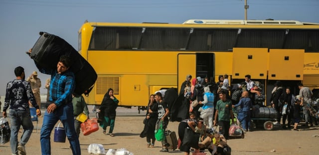 Un bus iranien dépose des réfugiés afghans à la frontière d'Islam Qala, dans la province d'Herat, le 24 juillet 2025 en Afghanistan