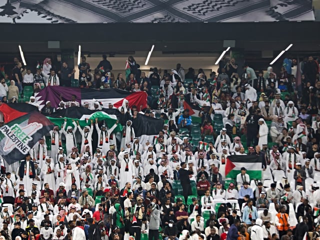 Fans are cheering during a charity football match, The Stand with Palestine, at the Education City Stadium in Doha, Qatar, on December 15, 2023. The match, which is part of the Stand with Palestine initiative, is being played at the Education City. The initiative is raising QR20 million to support people in Palestine, who have been subjected to Israeli aggression in Gaza. (Photo by Noushad Thekkayil/NurPhoto via Getty Images)