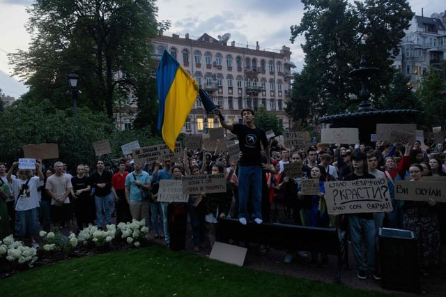 Manifestantes sostienen una bandera nacional y pancartas durante una manifestación en el centro de Kyiv el 22 de julio de 2025
