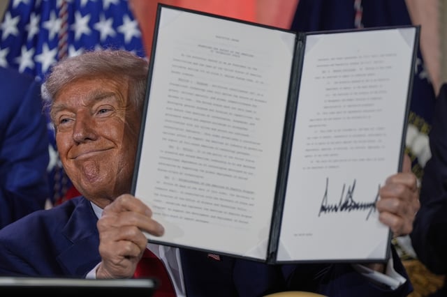 President Donald Trump holds a signed executive order after speaking during an AI summit at the Andrew W. Mellon Auditorium, Wednesday, July 23, 2025, in Washington. (AP Photo/Julia Demaree Nikhinson)