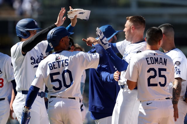 Jul 23, 2025; Los Angeles, California, USA;  Los Angeles Dodgers first baseman Freddie Freeman (5) celebrates with designated hitter Shohei Ohtani (17,left) and shortstop Mookie Betts (50) after hitting a game winning RBI single in the ninth inning against the Minnesota Twins at Dodger Stadium. Mandatory Credit: Kiyoshi Mio-Imagn Images