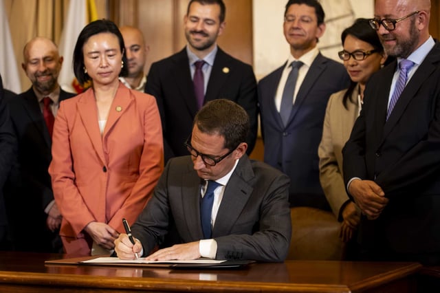San Francisco Mayor Daniel Lurie signs the city’s two-year, $15.9 billion budget during a ceremony at City Hall on Thursday.