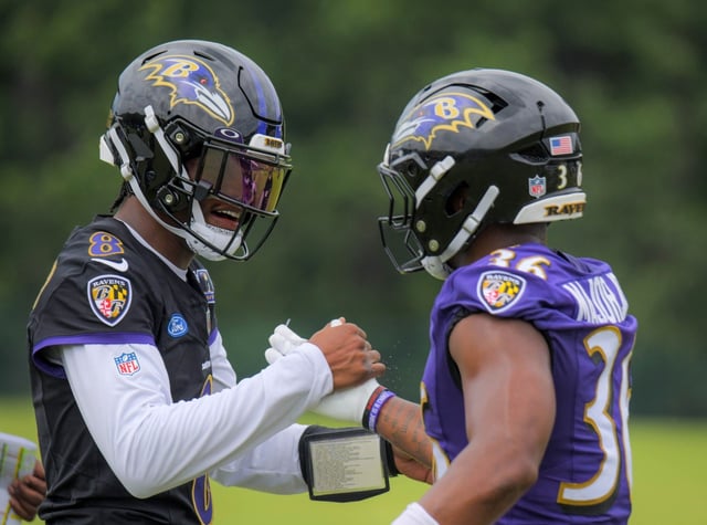 Baltimore Ravens quarterback Lamar Jackson shakes hands with running back Marcus Major Jr. during training camp. (Karl Merton Ferron/Staff)