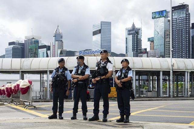 Police officers stand guard at a flag raising ceremony to mark the 28th anniversary of Hong Kong's return to Chinese rule in Hong Kong, Tuesday, July 1, 2025. (AP Photo/Chan Long Hei)