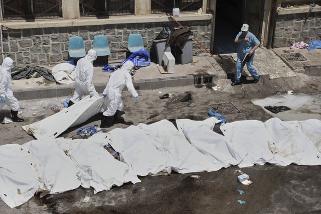 FILE - Morgue workers place the bodies of unidentified people killed during clashes between Bedouin clans and Druze militias, into plastic bags outside the National Hospital in Sweida, Syria, Monday, July 21, 2025. (AP Photo/Fahd Kiwan, File)
