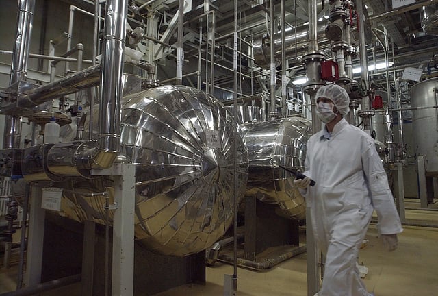 An Iranian security official in protective clothing walks through part of the Uranium Conversion Facility just outside the Iranian city of Isfahan, March 30, 2005.
