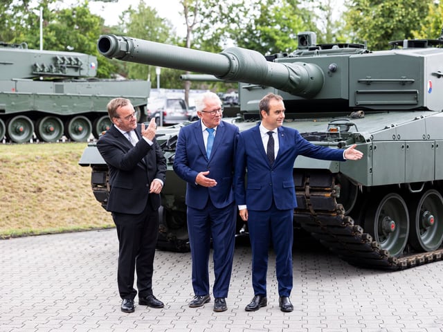 Boris Pistorius, Bundesminister der Verteidigung, Armin Papperger, Vorstandsvorsitzender der Rheinmetall AG, und Sebastien Lecornu, Verteidigungsminister von Frankreich, stehen bei einem Besuch des Werks vom Rüstungsunternehmen Rheinmetall vor einem tschechischen Kampfpanzer vom Typ Leopard 2 A4.
