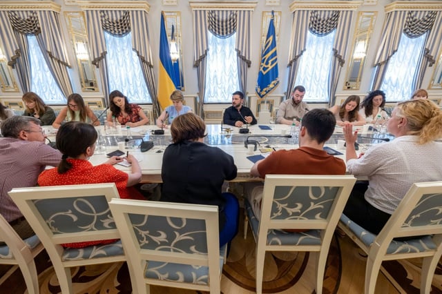 Photo prise et publiée par le service de presse de la présidence ukrainienne, le 24 juillet 2025, du président ukrainien Volodymyr Zelensky (c) lors d'une réunion avec des journalistes à Kiev