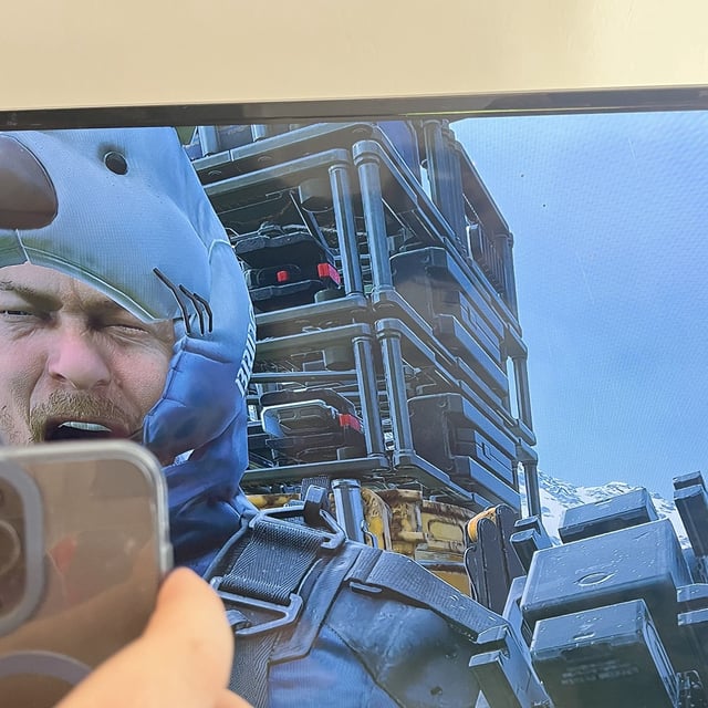 Sam Porter Bridges from Death Stranding looking at a phone and screaming