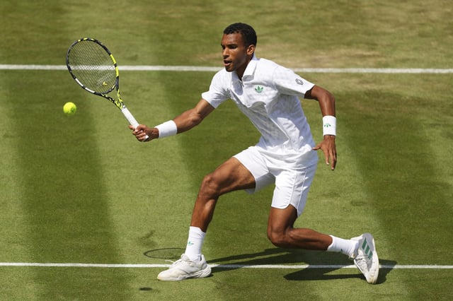Felix Auger‑Aliassime of Canada returns the ball to Jan-Lennard Struff of Germany during their second round men's singles match at the Wimbledon Tennis Championships in London, Thursday, July 3, 2025.(AP Photo/Kirsty Wigglesworth)