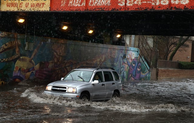 A motorist drives through standing water in a flooded underpass on April 18, 2013, in Chicago, Illinois.