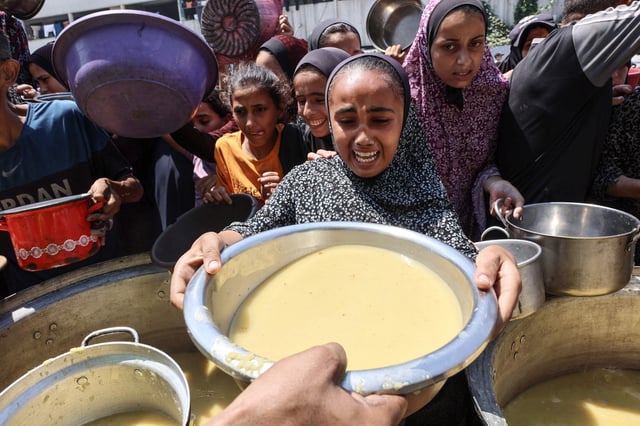 Una niña palestina desplazada reacciona al recibir sopa de lentejas en un punto de distribución de alimentos en la Ciudad de Gaza, en el norte de la Franja de Gaza, el 25 de julio de 2025.