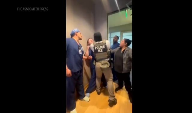 Medical staff at the Ontario Advanced Surgery Center face off with an Immigration and Customs Enforcement agent as he aims to take a Honduran landscaper into custody. (Image from video via AP)