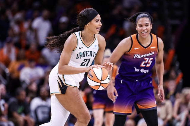 Isabelle Harrison #21 of the New York Liberty dribbles the ball and smiles with Alysssa Thomas #25 of the Phoenix Mercury during the fourth quarter at PHX Arena on June 27, 2025 in Phoenix, Arizona.