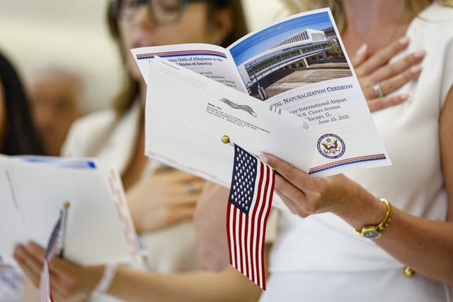New US citizens recite the Oath of Allegiance before receiving their naturalization certificates during a formal ceremony at Midway International Airport in Chicago, Illinois, on June 25, 2025.
